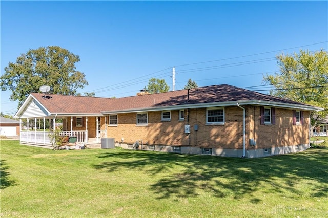 rear view of house with a yard, a porch, and cooling unit