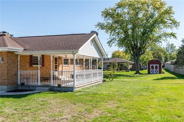 back of property with a yard, a porch, and a shed