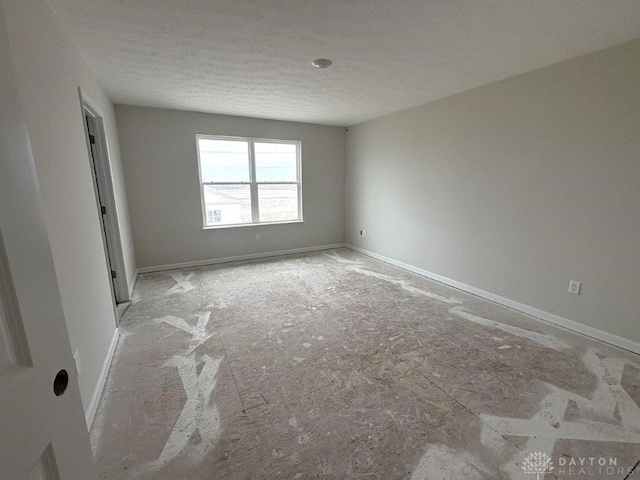 unfurnished room featuring a textured ceiling