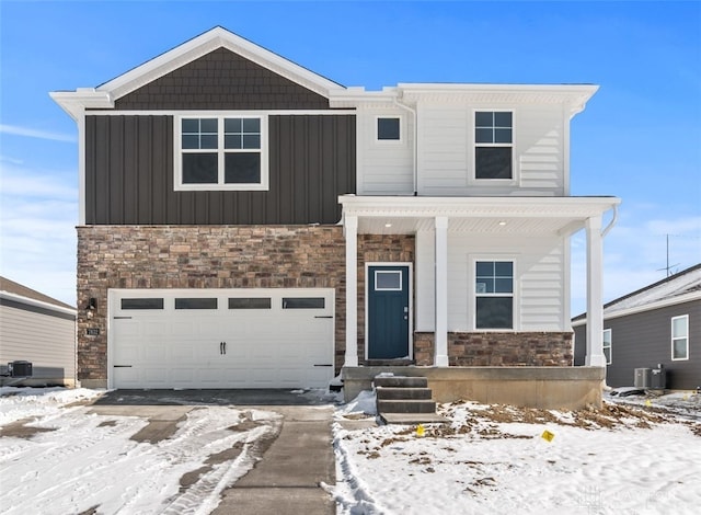 view of front of house with a garage, stone siding, board and batten siding, and cooling unit