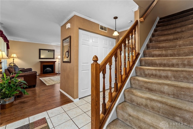 stairs featuring crown molding and hardwood / wood-style flooring