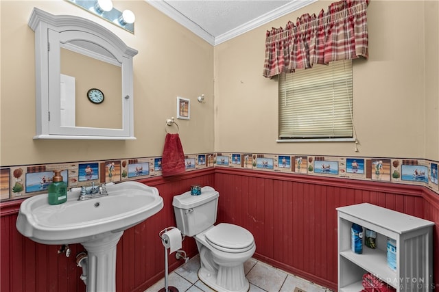 bathroom with ornamental molding, a textured ceiling, wooden walls, tile patterned flooring, and toilet