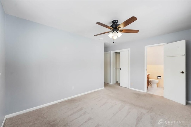 unfurnished bedroom featuring light carpet, connected bathroom, and ceiling fan