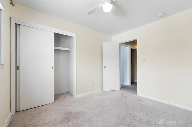 unfurnished bedroom with ceiling fan, light carpet, and a closet