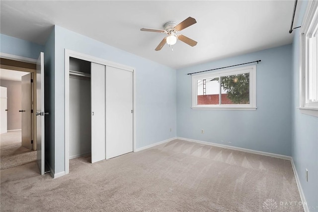 unfurnished bedroom featuring ceiling fan, light colored carpet, and a closet