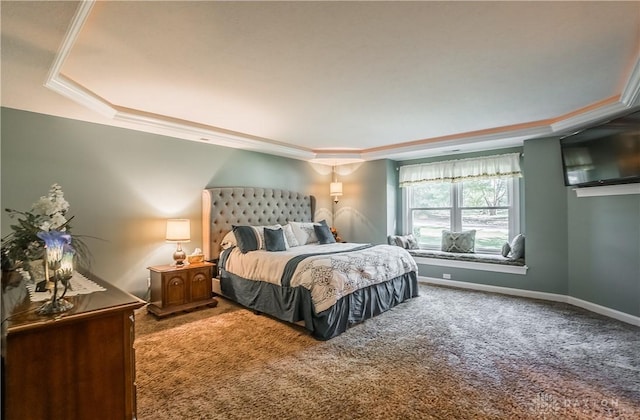 carpeted bedroom with a tray ceiling, baseboards, and ornamental molding