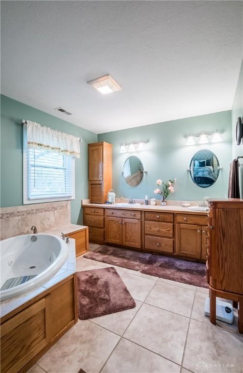 bathroom featuring vanity, tile patterned floors, and a bathtub