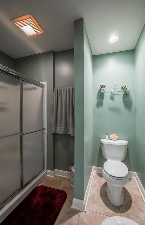 full bathroom with tile patterned flooring, a shower stall, toilet, and baseboards