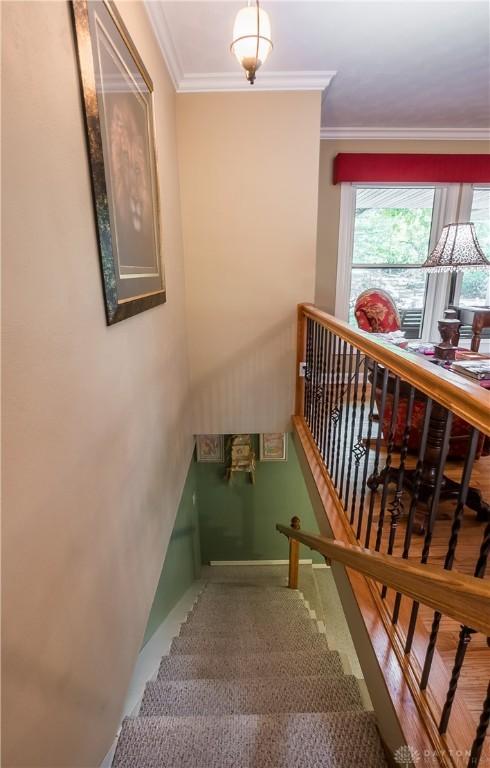 stairs featuring crown molding