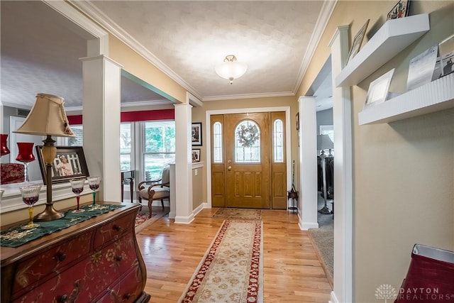 foyer entrance with light wood finished floors, crown molding, and baseboards