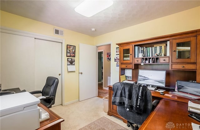 office area with visible vents and light colored carpet