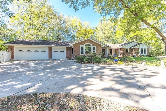 ranch-style house featuring a garage, brick siding, driveway, and fence