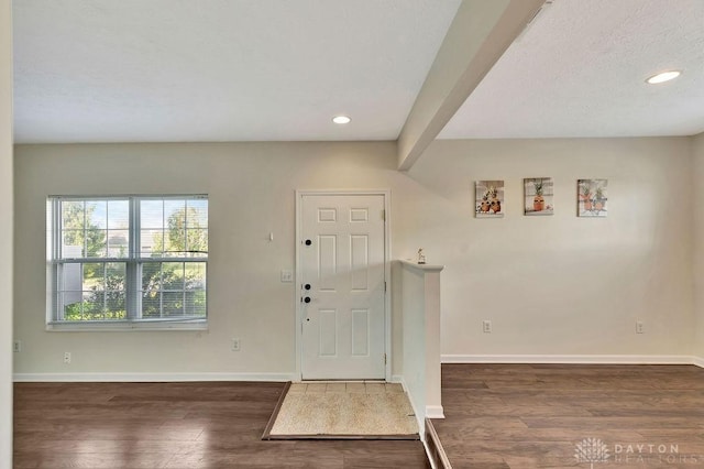 entryway featuring beamed ceiling and dark hardwood / wood-style flooring