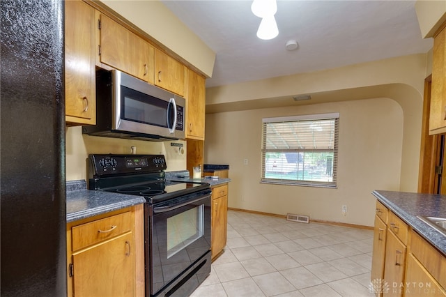 kitchen with black electric range oven and light tile patterned floors