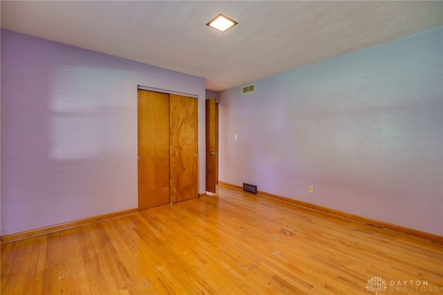 unfurnished bedroom with a closet and light hardwood / wood-style flooring