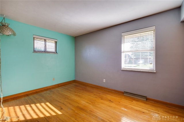 spare room featuring a wealth of natural light and light hardwood / wood-style flooring