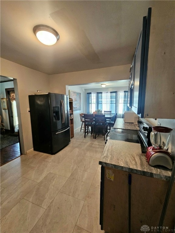 kitchen with stainless steel electric range oven and black fridge