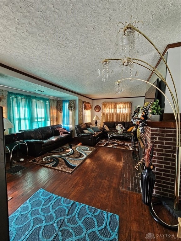 living room with hardwood / wood-style flooring, crown molding, and a textured ceiling