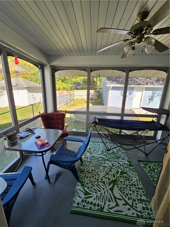 sunroom / solarium featuring ceiling fan, wood ceiling, and a healthy amount of sunlight