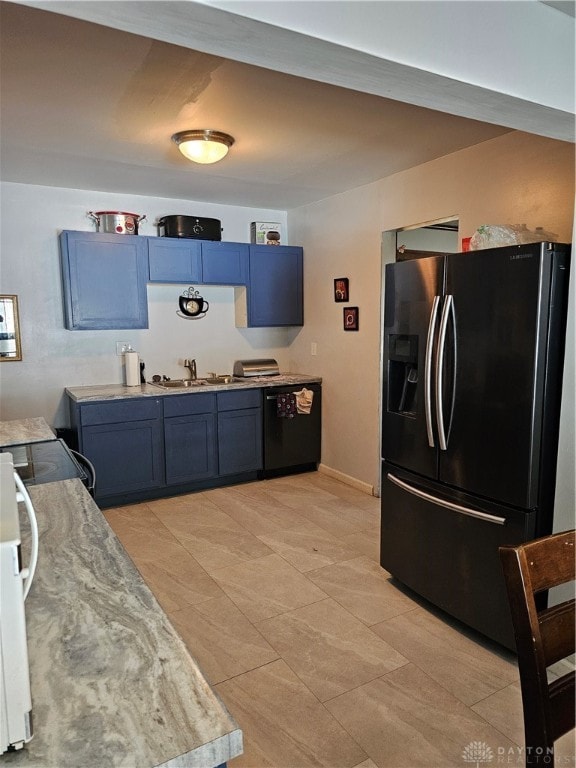 kitchen with blue cabinets, light tile patterned flooring, appliances with stainless steel finishes, and sink