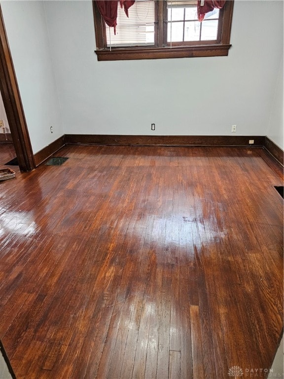 unfurnished room with dark hardwood / wood-style flooring