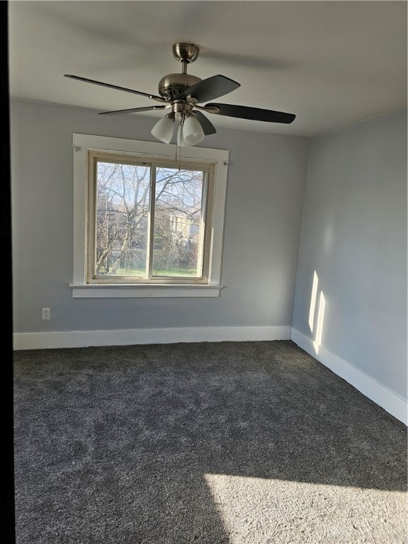 unfurnished room with dark colored carpet and ceiling fan