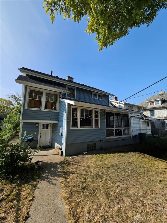 view of front facade with a sunroom and a front yard