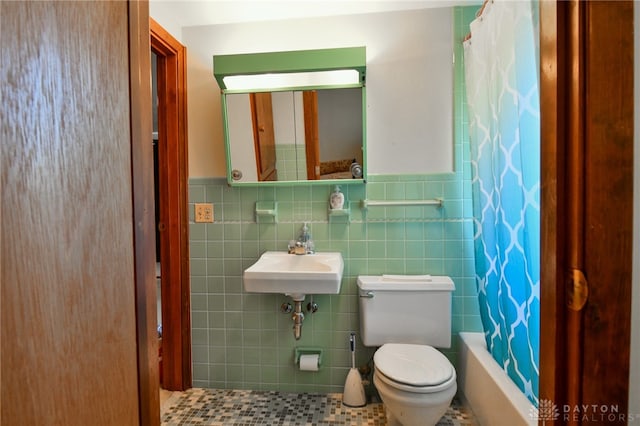 full bathroom featuring tile patterned floors, toilet, shower / bath combination with curtain, sink, and tile walls