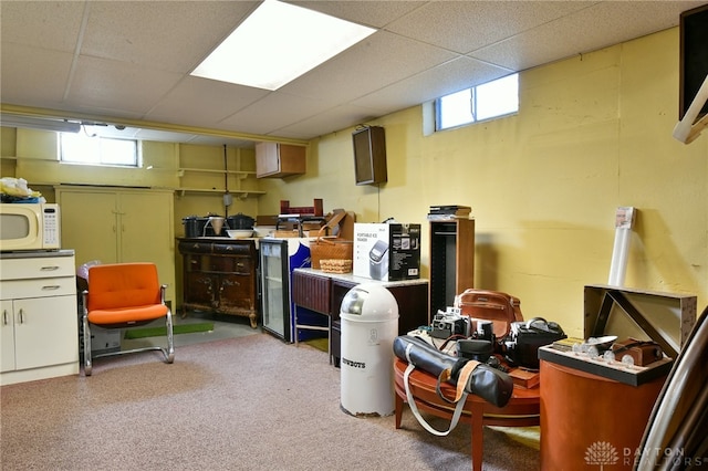 basement with light carpet, a paneled ceiling, and plenty of natural light