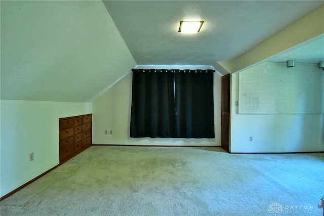 bonus room featuring vaulted ceiling and light colored carpet