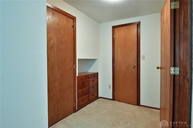 corridor featuring light colored carpet