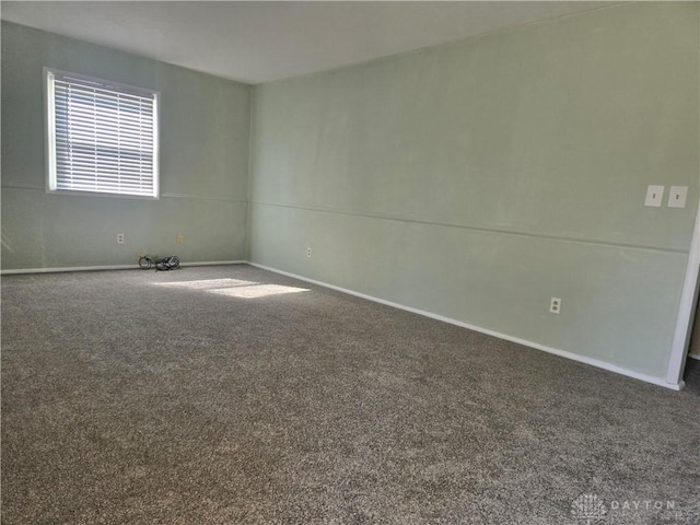 unfurnished room featuring carpet flooring and baseboards