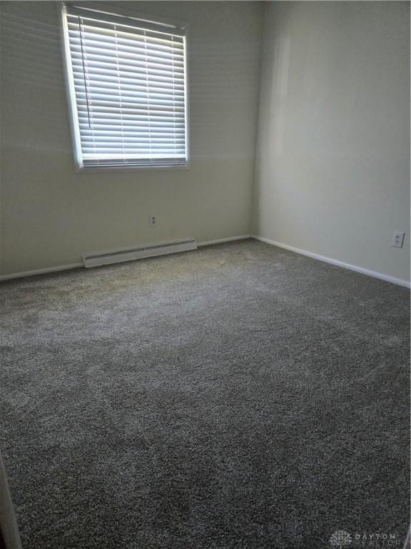 carpeted empty room featuring baseboards and a baseboard heating unit