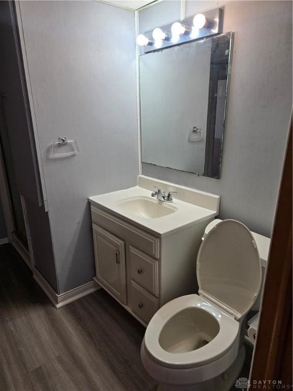 bathroom featuring vanity, baseboards, and wood finished floors