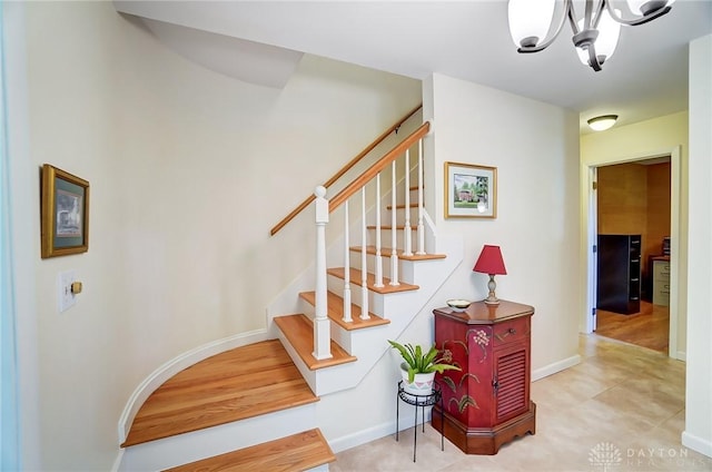 stairs with a notable chandelier