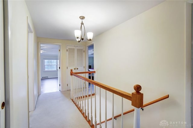 corridor with light colored carpet and an inviting chandelier