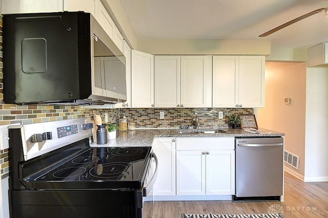 kitchen featuring white cabinets, stainless steel appliances, light stone countertops, and sink