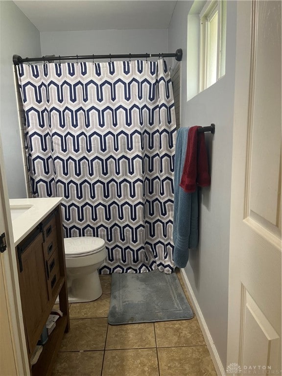 bathroom with tile patterned flooring, vanity, toilet, and curtained shower