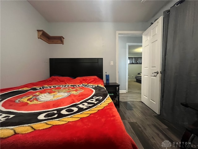 bedroom with dark hardwood / wood-style flooring