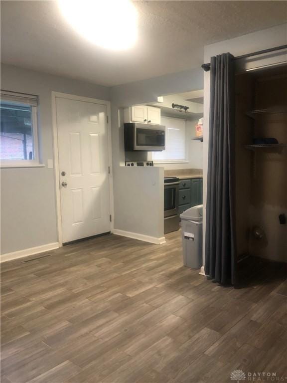 kitchen with dark hardwood / wood-style floors, white cabinetry, and stainless steel appliances