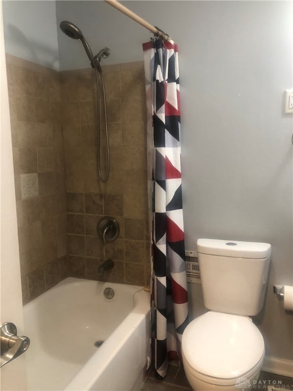 bathroom with shower / bath combination with curtain and toilet