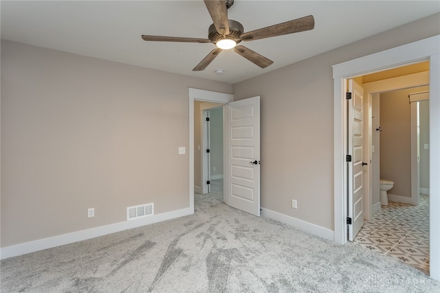 unfurnished bedroom featuring light colored carpet, connected bathroom, and ceiling fan