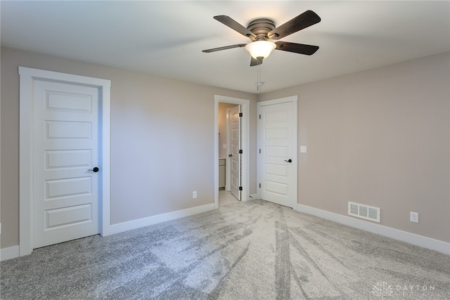 spare room featuring light colored carpet and ceiling fan