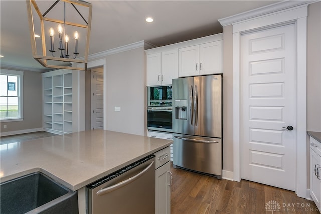 kitchen featuring ornamental molding, white cabinetry, stainless steel appliances, dark hardwood / wood-style floors, and an inviting chandelier