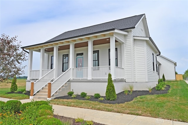 view of front facade with a front yard and covered porch