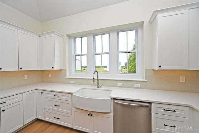 kitchen with sink, plenty of natural light, white cabinetry, and stainless steel dishwasher