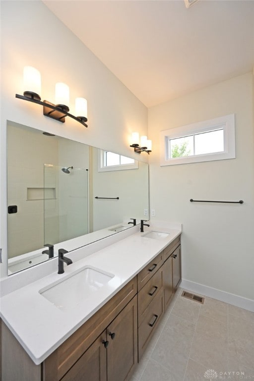 bathroom with tile patterned floors, vanity, and tiled shower