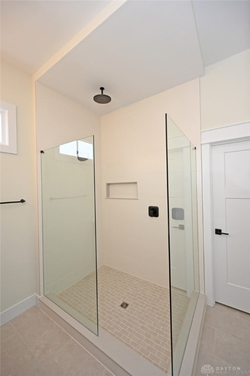 bathroom with tile patterned flooring and tiled shower