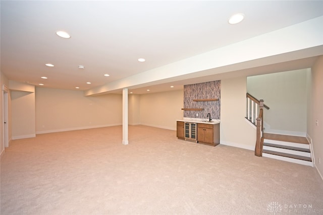 basement featuring light colored carpet and sink