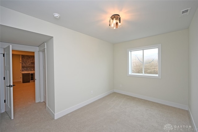 unfurnished room featuring light carpet